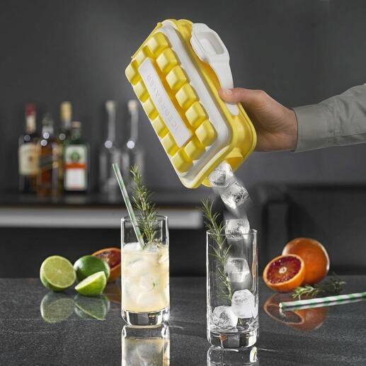 Hand houdt Ice-Pop ijsblokjesvorm, ijsblokjes stromen in een glas met drank.