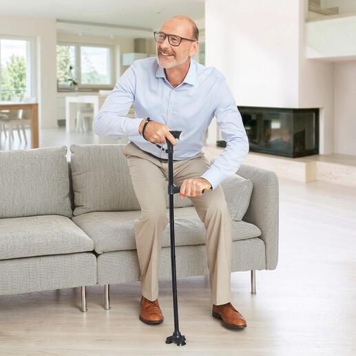 Persoon zit met Clever Cane loop- en opstahulp op de bank.