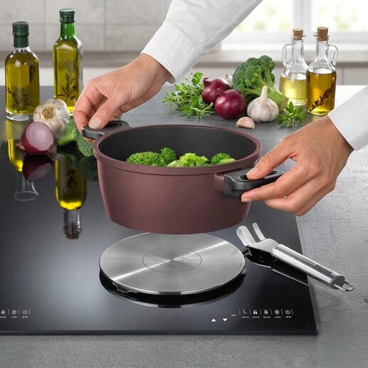 Inductie-adapterplaat met broccoli in een pan ernaast.