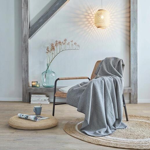 Wollen fleece deken op een stoel in een moderne woonkamer.