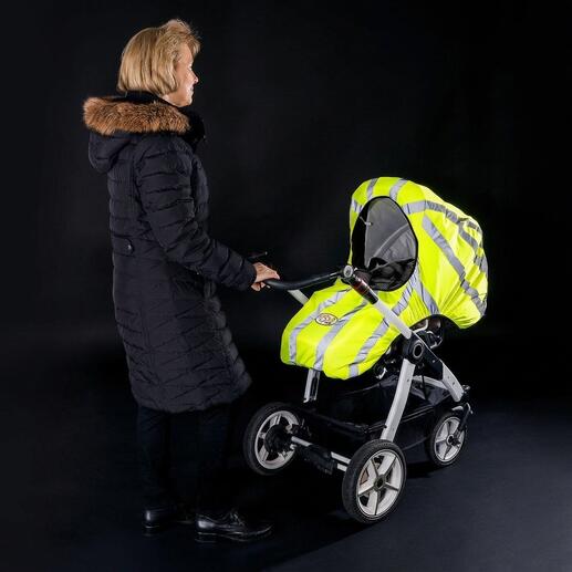 Vrouw met kinderwagen waarschuwingsvest, zichtbare reflecterende strepen, op een donkere achtergrond.