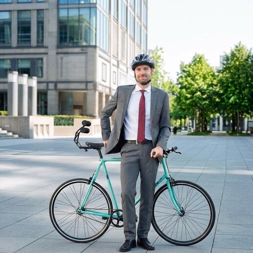 Man in pak staat met fiets en Tshobo fietssteun buiten.