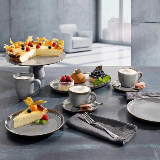 Servies met verschillende borden, mokken en taart op een tafel.