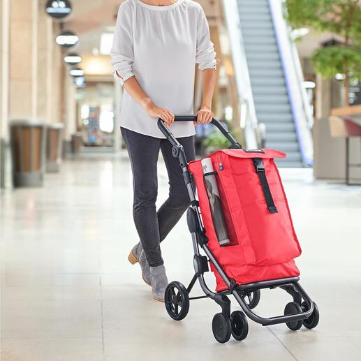 Vrouw duwt een rode boodschappenwagen Go up Premium in een moderne ruimte.