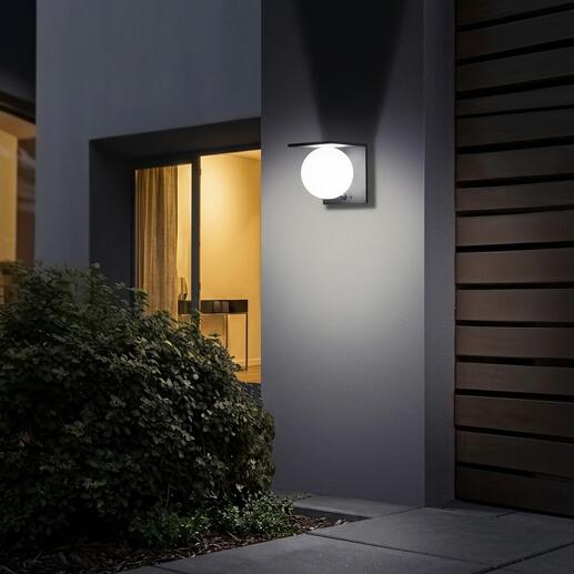 Zonnebollenwandlamp verlicht zacht op een muur.