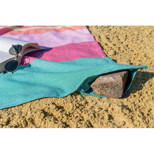Vul de hoekvakken met stenen of zand: zo vliegt het strandlaken ook bij wind niet snel weg.