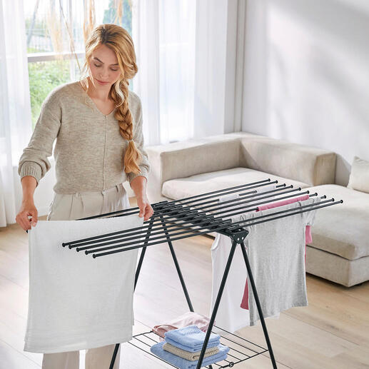 Vrouw organiseert was op een design wasdroger in de woonkamer