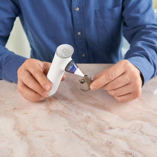 Mini-stofzuiger in de hand met gebruik van een opzetstuk