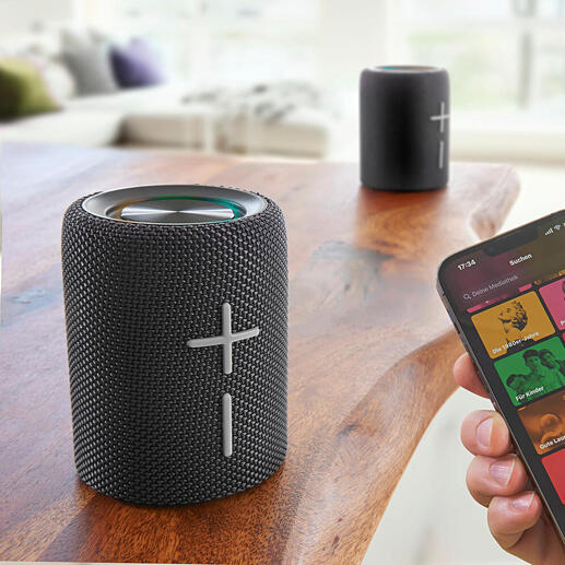 Smartphone toont muziek-streaming-app naast deelbare Bluetooth-luidspreker.