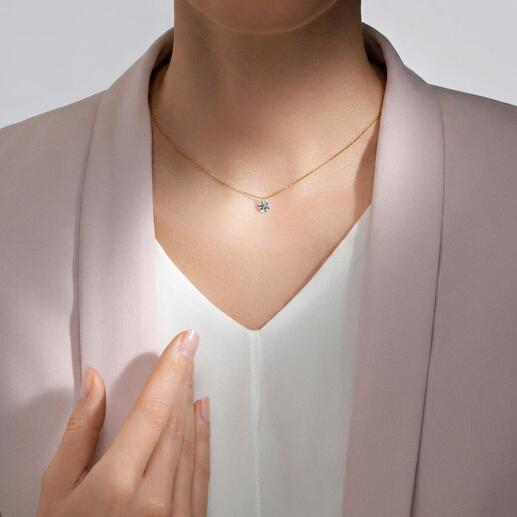 Decoratieve ketting met zwevende moissaniet hanger, gedragen door een persoon.