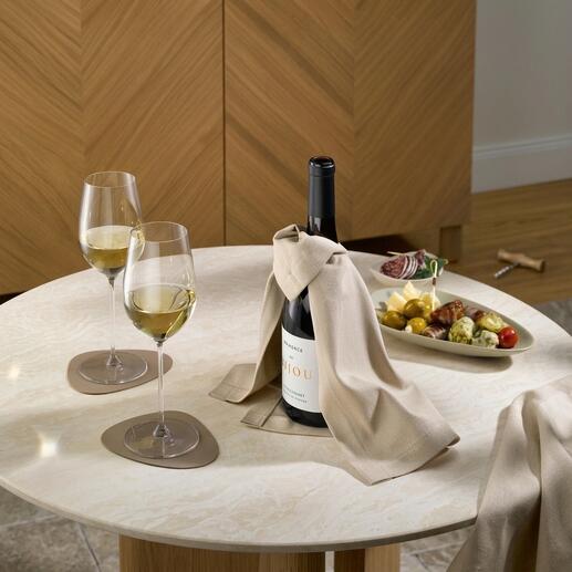 Wijncape met een fles wijn en twee glazen op een tafel.