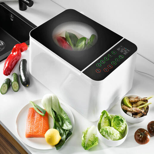 Food Washer-apparaat op aanrecht, omringd door verse groenten.