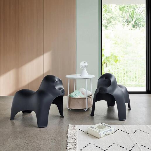 Twee zwarte gorillahockers staan in een moderne woonkamer met een tafel.