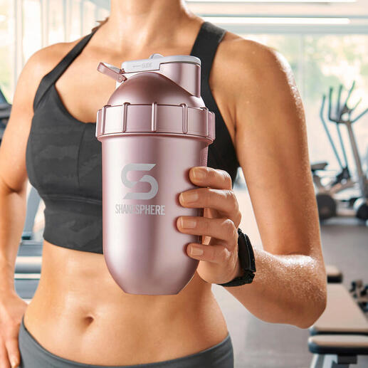 Vrouw houdt een roze shaker vast in een sportschool.