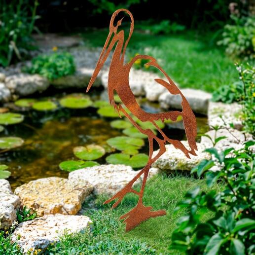 Tuinsteek in de vorm van een reiger van roestkleur in de tuin