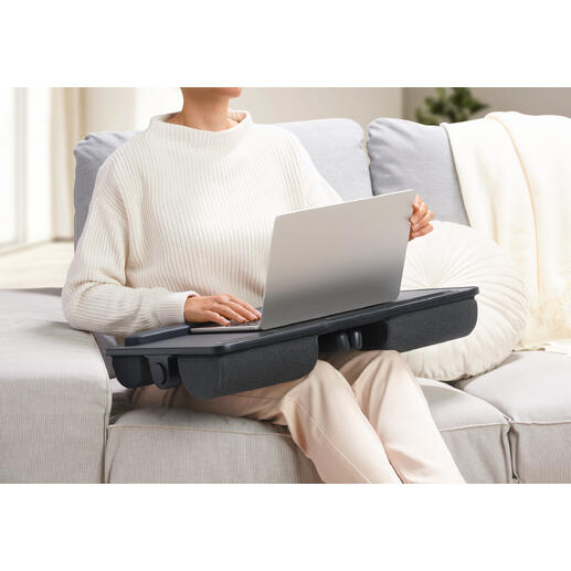 Persoon met een 2-in-1 laptopkussen op schoot dat als tafel fungeert.