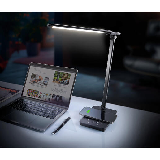 Dynamische LED-bureau lamp op een bureau naast een laptop