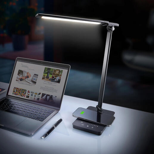 Dynamische LED-bureau lamp op een bureau naast een laptop