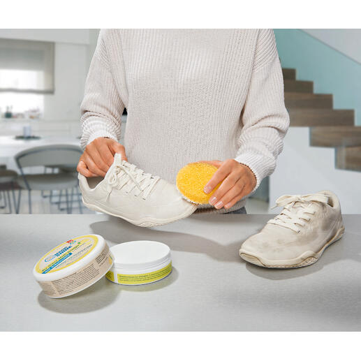 Ook ideaal om uw witte sneakers mee schoon te maken. Vrouw maakt witte schoenen schoon met een spons en universeelreiniger.