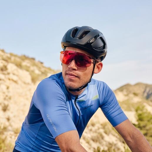 Fietser met rode sportzonnebril en zwarte helm op een pad.