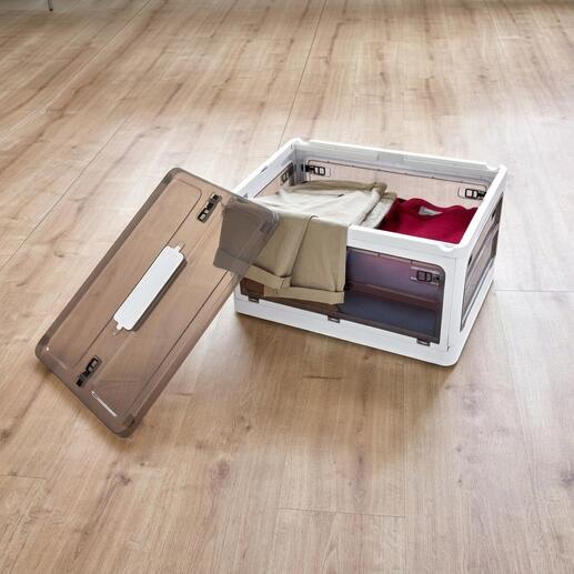 Open opbergdoos met kleding op houten vloer.