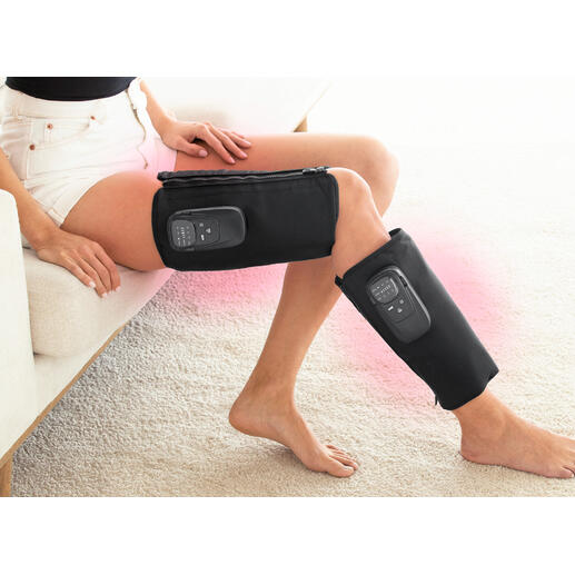 Vrouw met een compressiemassageapparaat op haar benen terwijl ze zit.
