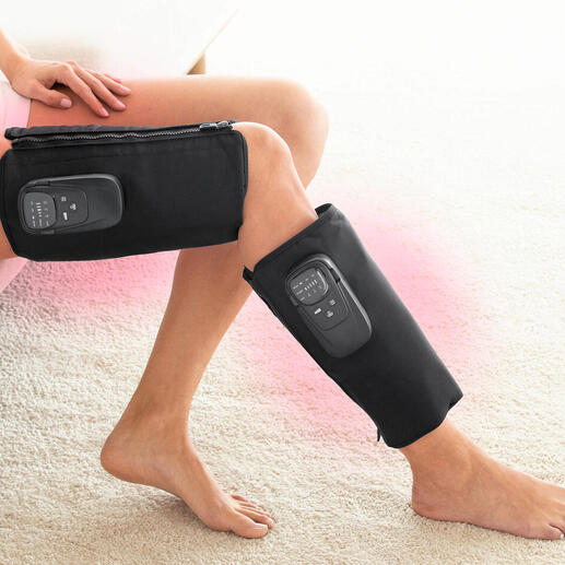 Vrouw met een compressiemassageapparaat op haar benen terwijl ze zit.