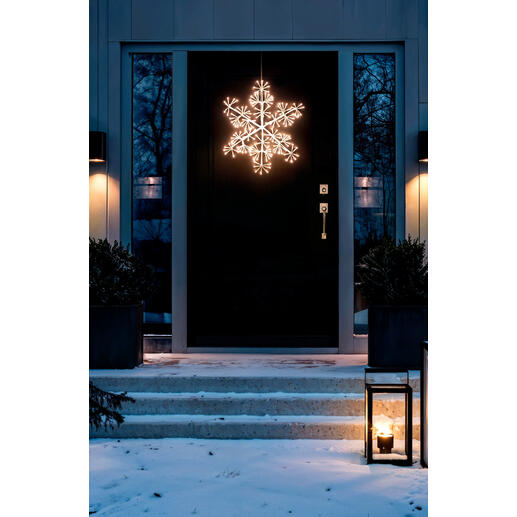 Verlichte LED-sneeuwvlok voor buiten, hangend voor een voordeur.