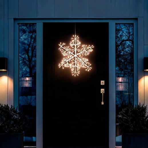 Verlichte LED-sneeuwvlok voor buiten, hangend voor een voordeur.