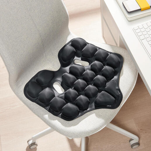 Zwart ergonomisch zitkussen op een stoel.