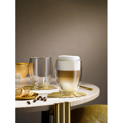 Twee premium thermobekers op tafel, één met schuimige drank en één leeg.