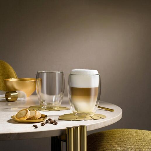 Twee premium thermobekers op tafel, één met schuimige drank en één leeg.