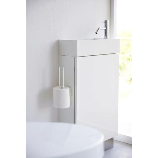 Witte design toiletrolhouder bevestigd aan een modern badkamermeubel.