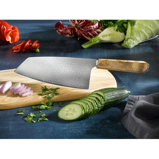 Nakiri-mes van damaststaal Exclusief bij Pro-Idee: het handgeslepen nakiri-mes met een 66-laags damastlemmet van Japans staal. Damast Nakiri-mes op een houten plank, omringd door verse groenten.