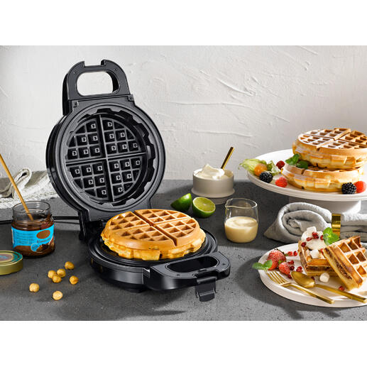 Extra diep wafelijzer met verse wafels en ingrediënten op een tafel.
