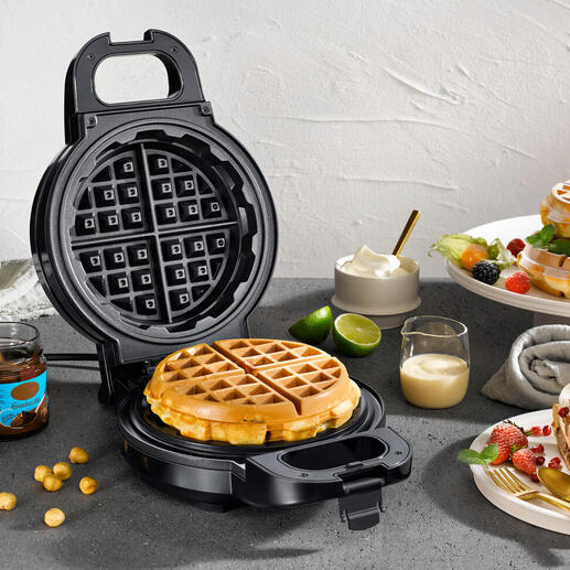 Extra diep wafelijzer met verse wafels en ingrediënten op een tafel.