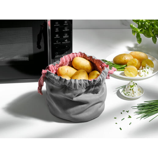 Grijze aardappelgarbeutel met aardappelen en kruiden op de tafel.