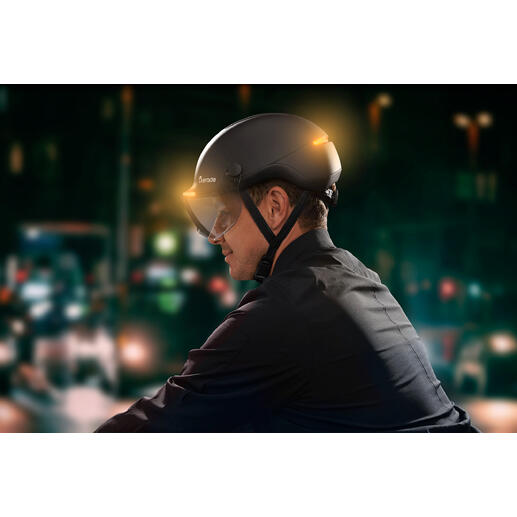 Man draagt een fietshelm met lichtsignaal in de stad bij nacht