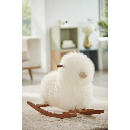 Echt schapenvacht schommel schaap in het wit op een vloerkleed.