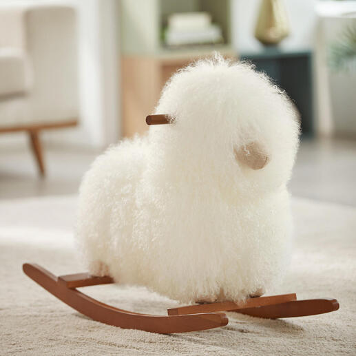 Echt schapenvacht schommel schaap in het wit op een vloerkleed.