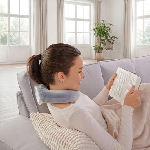 Vrouw ontspant met warm-koud kussen en leest op de bank.