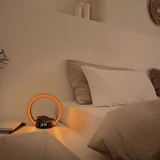 Wecker met ronde, verlichte display op een nachtkastje.