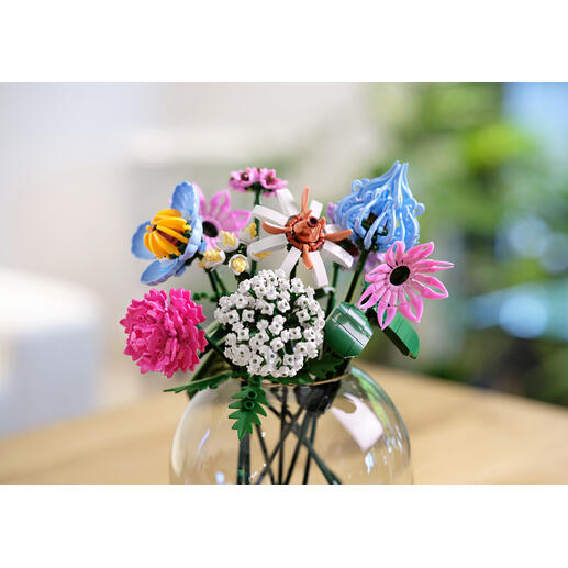 Bloemstuk van bouwstenen in rosé- en lila tinten in een vaas.