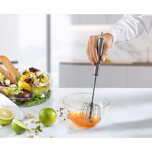 Handmixer met een garde om ingrediënten te mengen in een kom