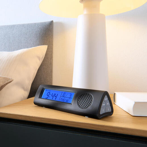 Radio-alarmklok met LED-zaklamp op nachtkastje naast bed