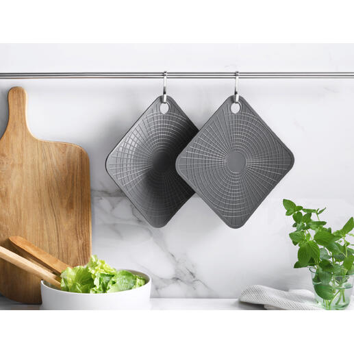Twee grijze silicone ovenwanten hangen aan een stang in een moderne keuken.
