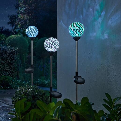 Drie solar tuinstekers met kleurrijke mozaïek lampen in de tuin.