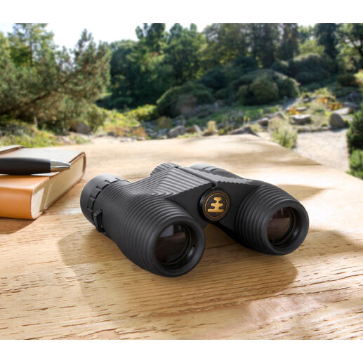 Compacte verrekijker op een houten tafel in de natuur.