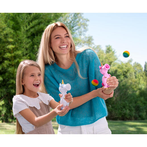 Vrouw en meisje lachen terwijl ze buiten met eenhoorn-ploppers spelen.