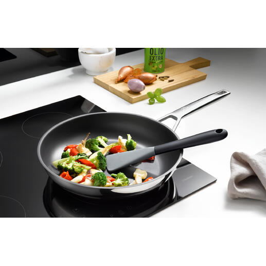 Flexibele siliconen spatel in een pan met gemengd groenten.